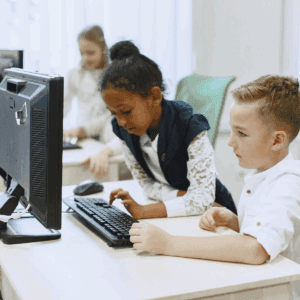 elementary students learning digital tools on the computer